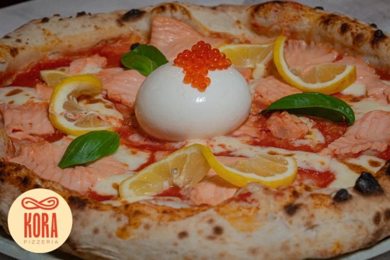 Gourmet salmon pizza with smoked salmon, caviar, creamy burrata cheese, mozzarella, fresh basil, and lemon