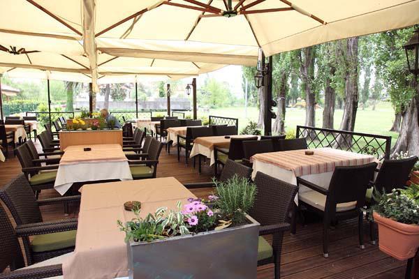 Cozy outdoor terrace of Konoba Girasole in Solin, featuring a rustic wooden setting and natural shade