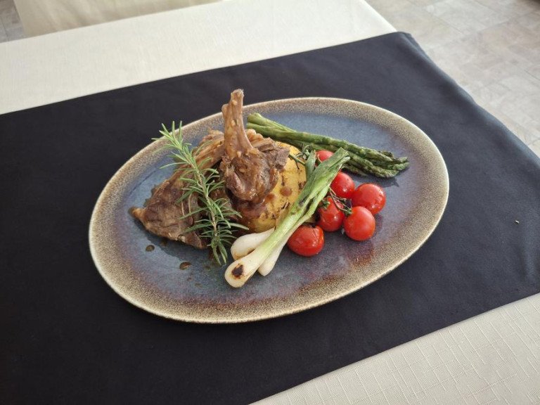 Roasted lamb chops served with spring onions, asparagus, and cherry tomatoes
