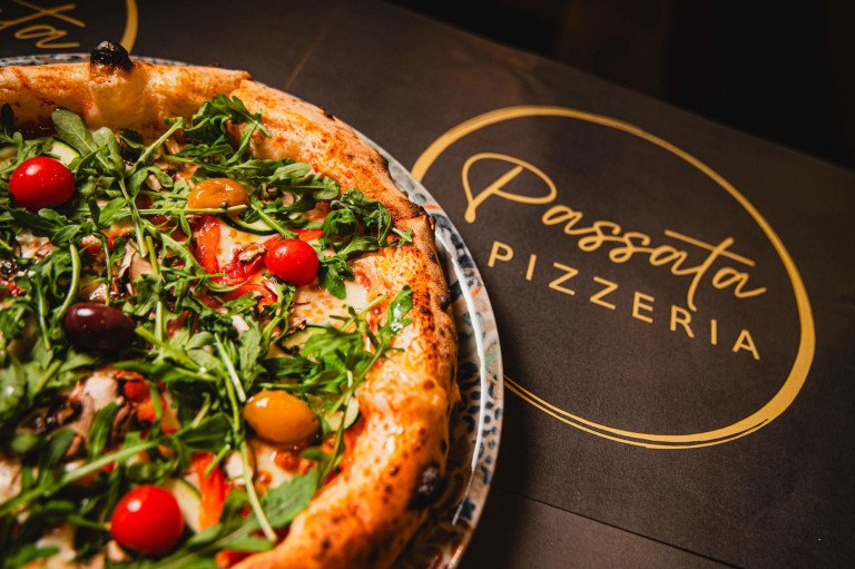 Sočna Napoletana pizza sa svježom rikolom, cherry rajčicama, maslinama i gljivama uz branded podložak Pizzerije Passata u Zagrebu