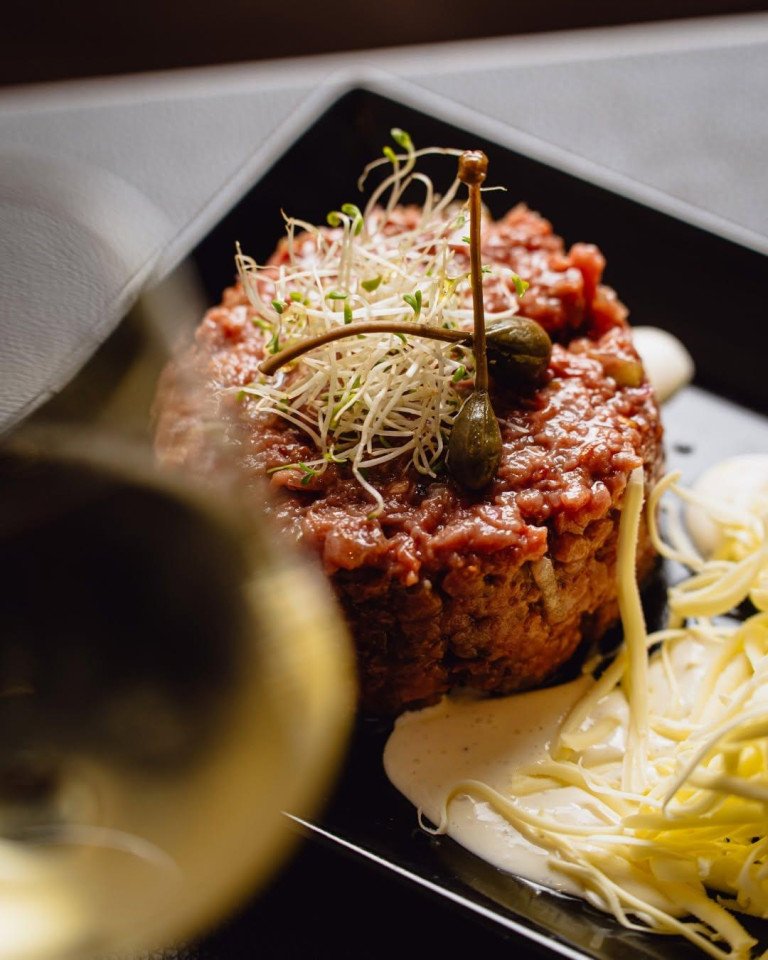 Classic steak tartare garnished with sprouts and capers served at The Bank Split